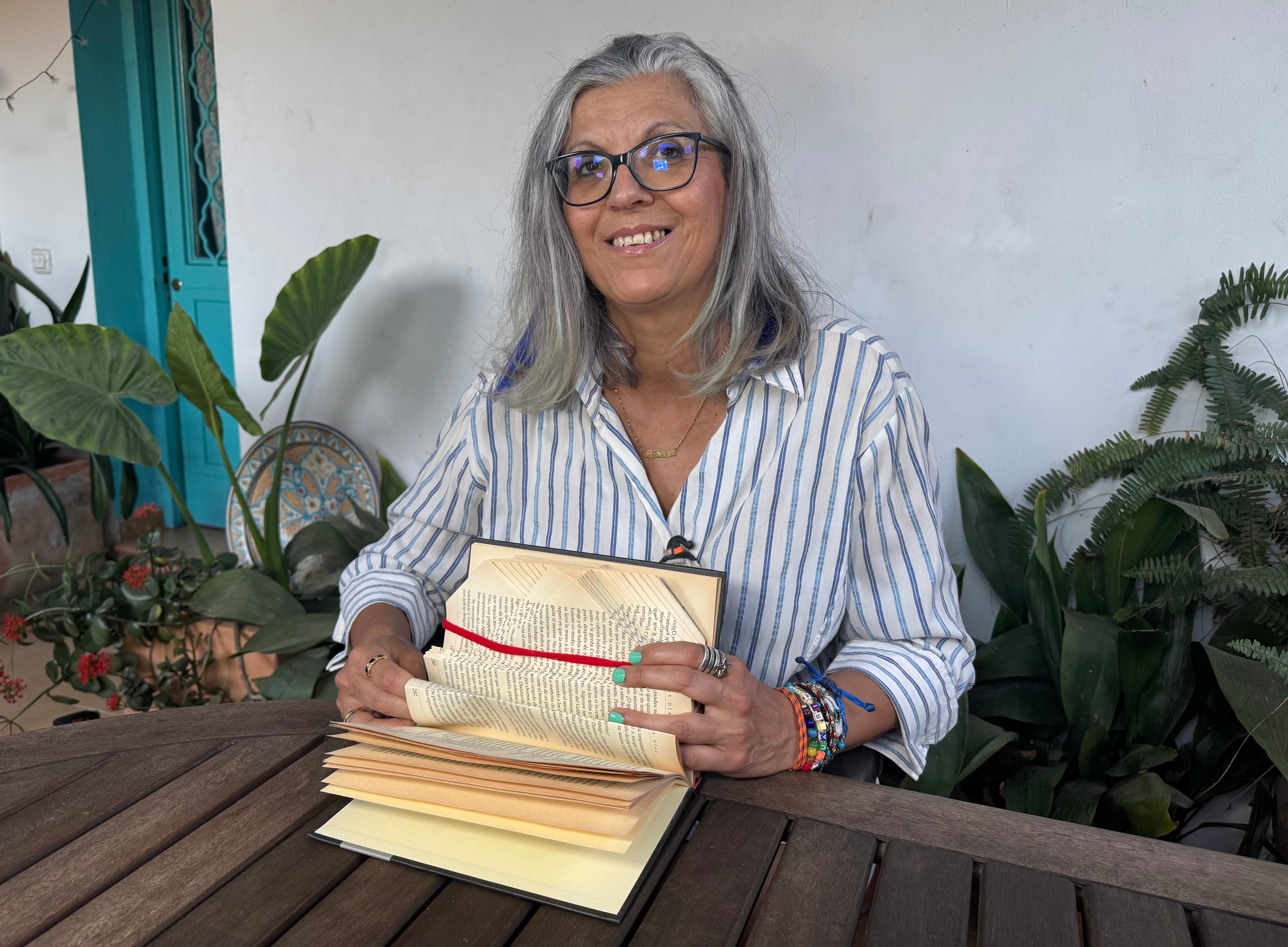 Luisa creando Book Art con un libro entre sus manos